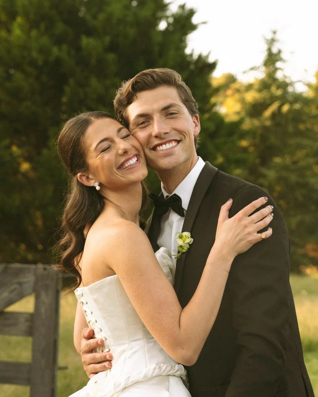 Happy bride and groom embracing at sunset