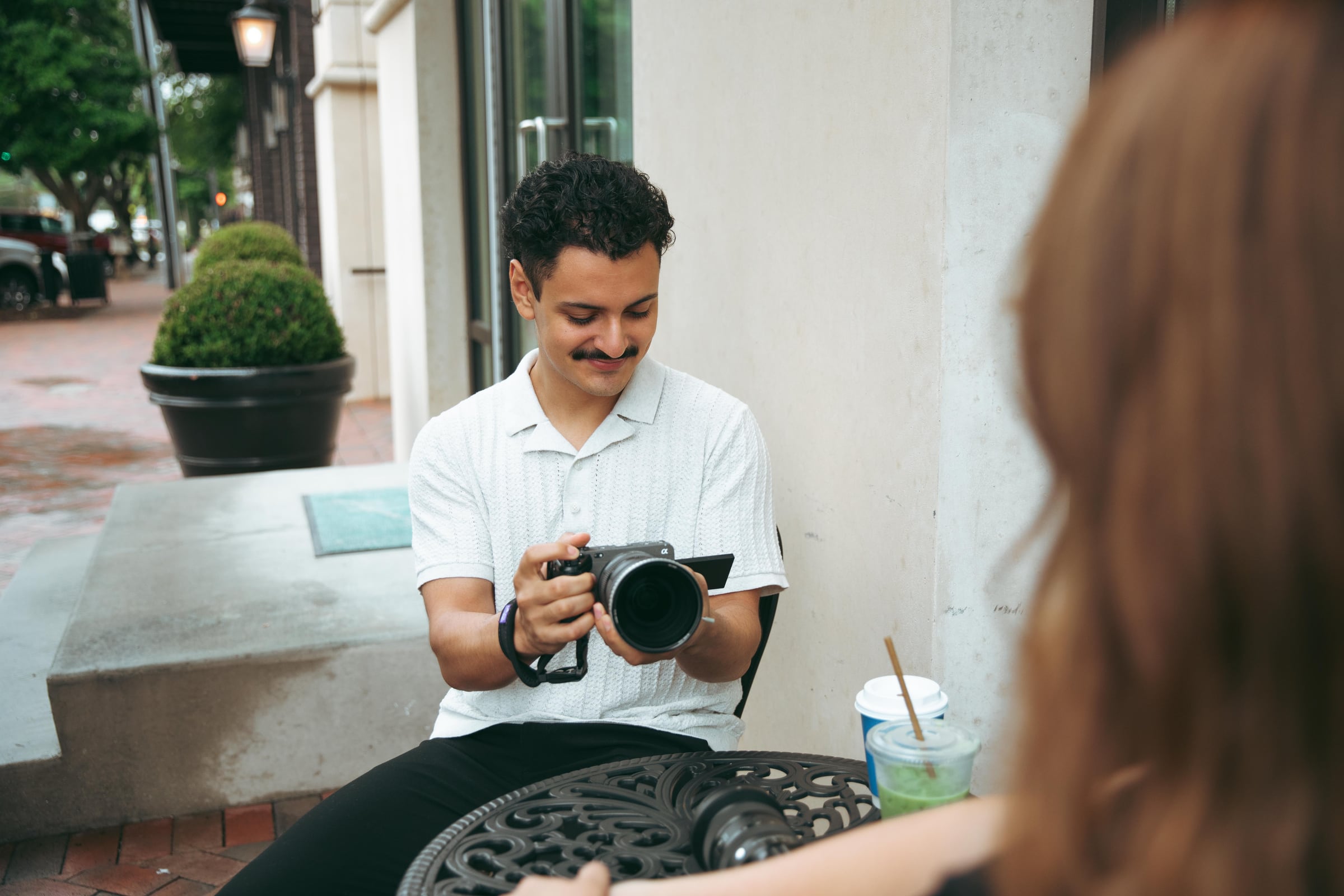 Mario smiling at a table outdoors